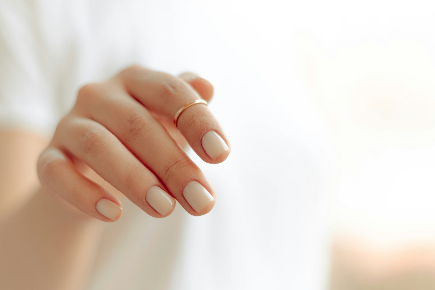 Imagen de referencia: mano con manicura natural sobre fondo claro